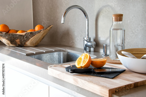 modern kitchen sink with cutting board with fresh oranges.