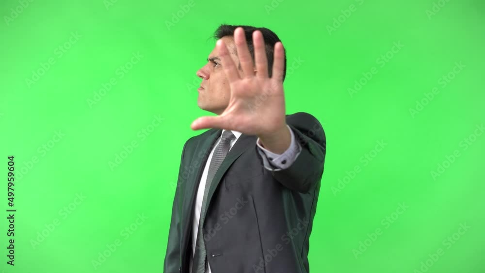 Displeased man showing stop gesture and turning head away Displeased man showing stop gesture and turning head away