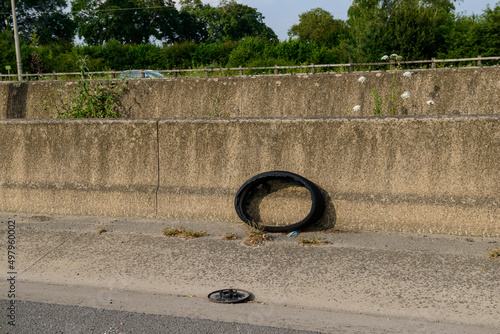 Broken tire left as rubbish on the side of the road