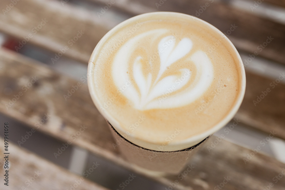 Soft focus of Latte art hot coffee in eco paper cup on table background ...