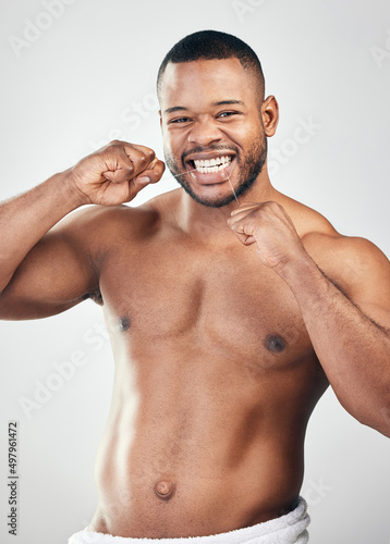 Take extra care of your smile. Studio portrait of a handsome young man flossing his teeth against a white background.