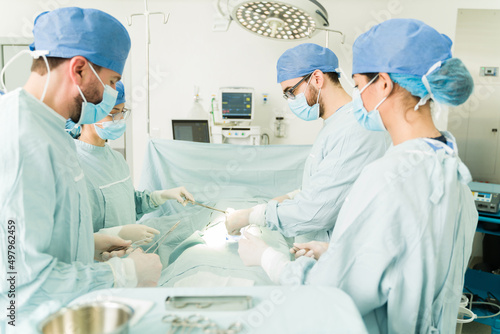 Four surgeons operating a patient