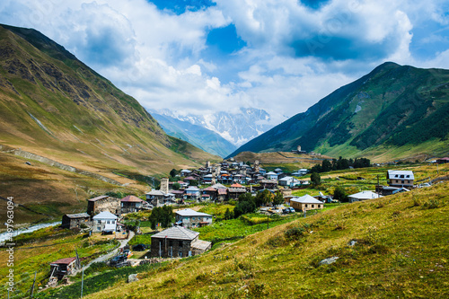 Village Ushguli landscape with massive rocky mountains photo