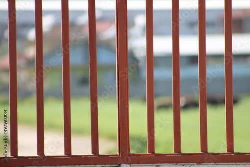 Rusty iron railing of prison with blurred nature background. End of the road, no more way concept. Metaphoric or analogical expression of the opposition between freedom and captivity. 