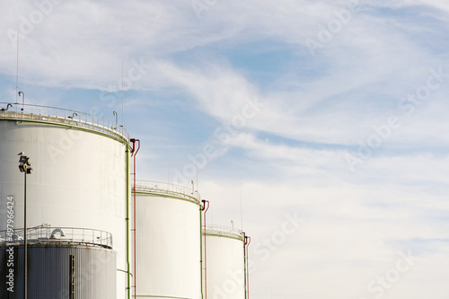 Fuel tank storage terminal on a sunny day with empty space on the right side, diagonal composition