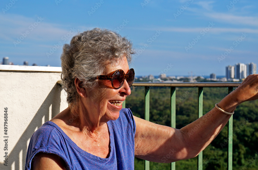 Elderly woman sunbathing on the balcony, Rio de Janeiro