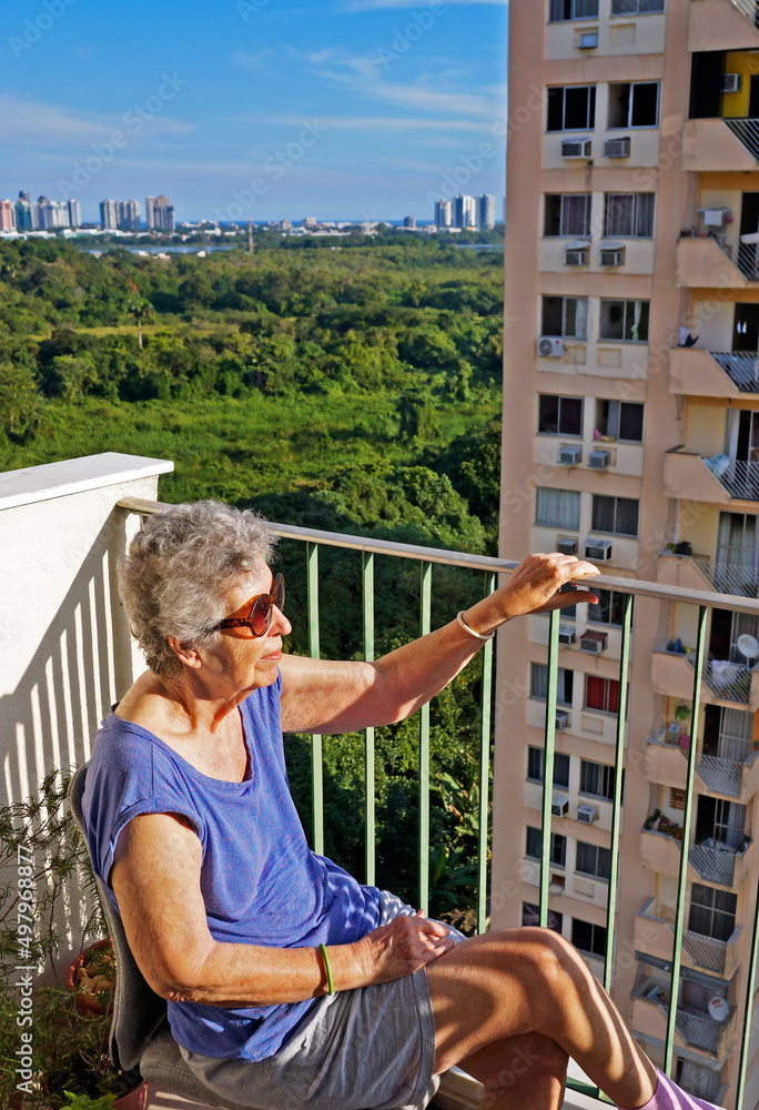 Elderly woman sunbathing on the balcony, Rio de Janeiro