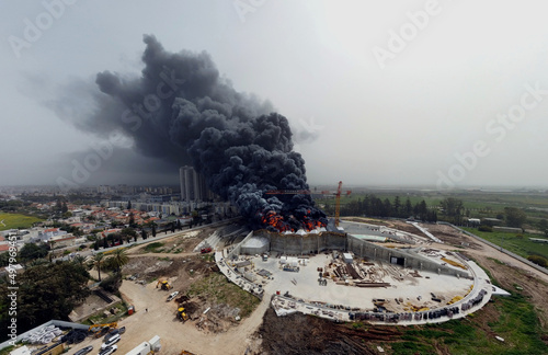 Acre, Israel - April 8 2022: Bahai construction site caught fire and huge smoke pillar covering residential neighborhood 