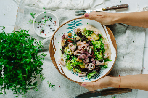 Salad with chickpeas, baby squid, baby octopus, cherry tomatoes, lettuce, arugula and hummus. Italian-French dish from the island of Corsica