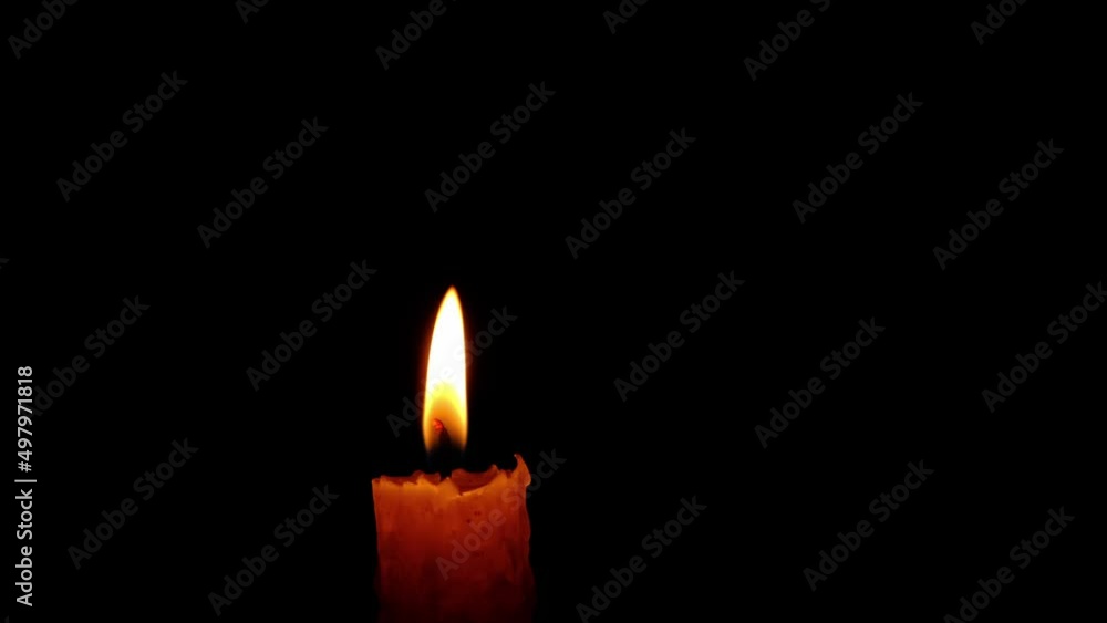 Paraffin candle burning in dark with bright flame. Paraffin candle burning in dark with bright flame.