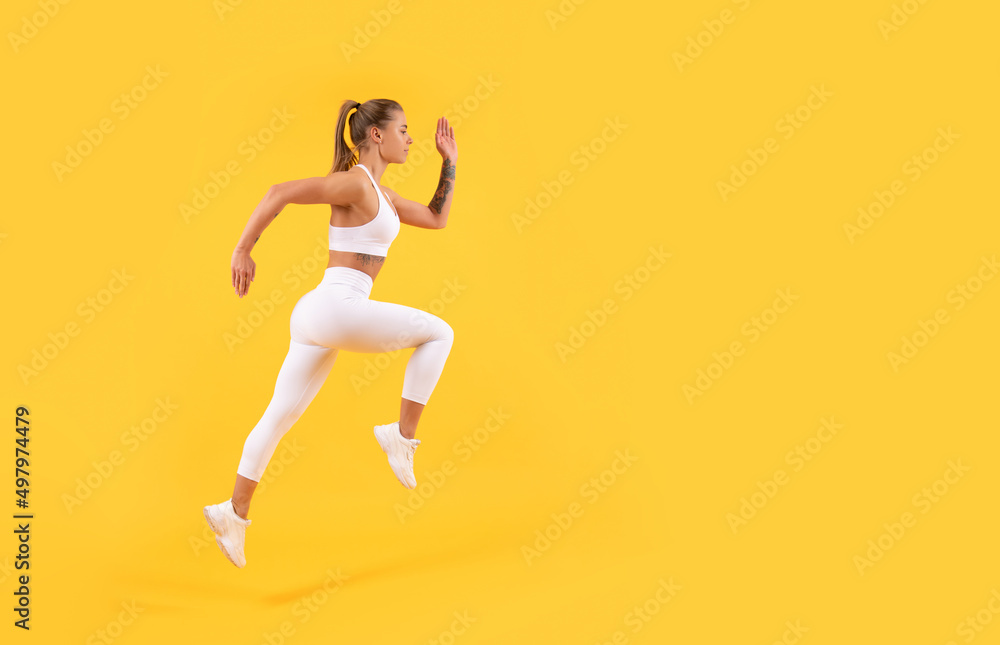 sport girl runner running on yellow background with copy space