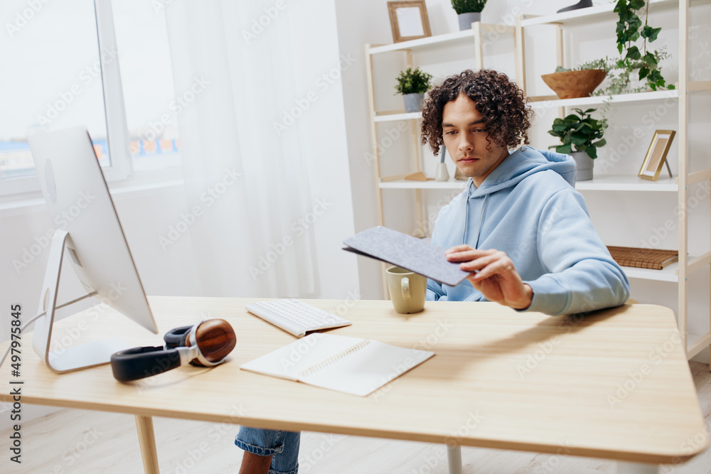 portrait of a man in a blue jacket in front of a computer with phone interior portrait of a man in a blue jacket in front of a computer with phone interior