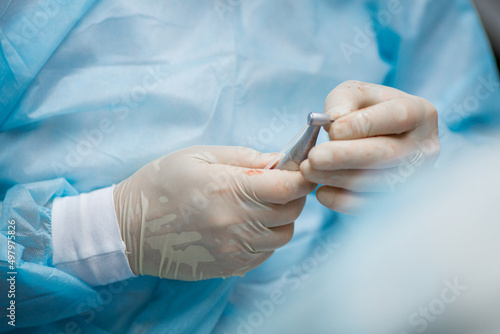 Professional dentist holding stomatological tool in hospital during surgery