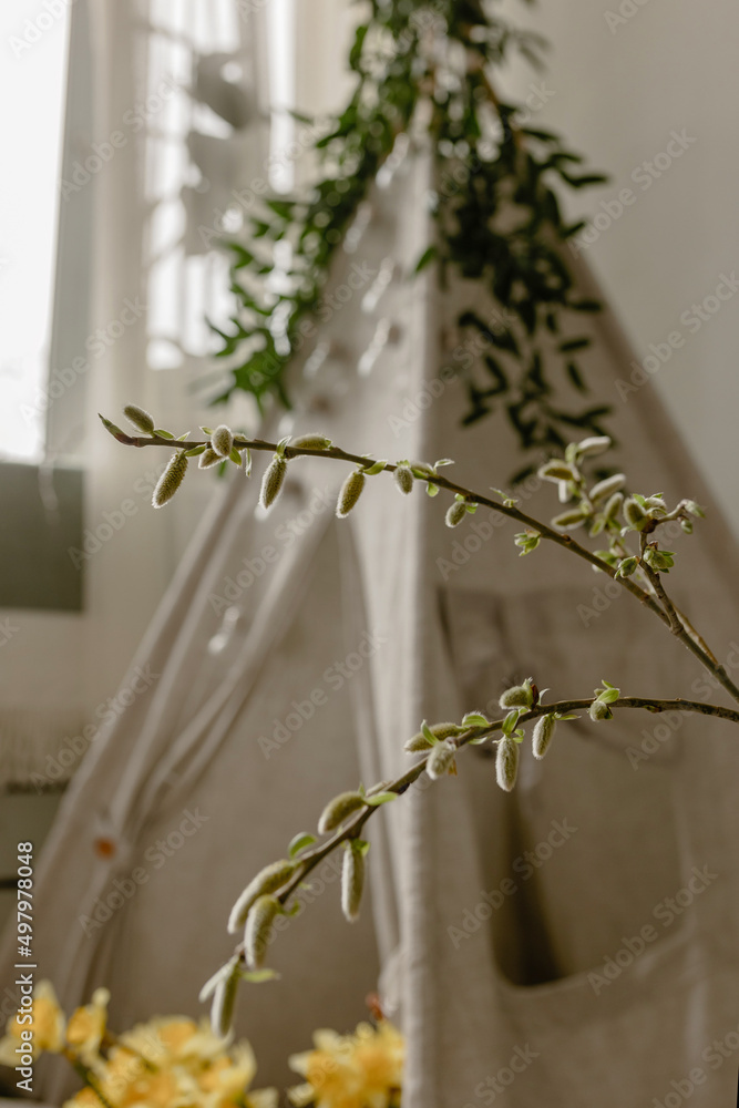 Flowering branch against the background of a children's wigwam. Spring photozone. Spring interior Flowering branch against the background of a children's wigwam. Spring photozone. Spring interior