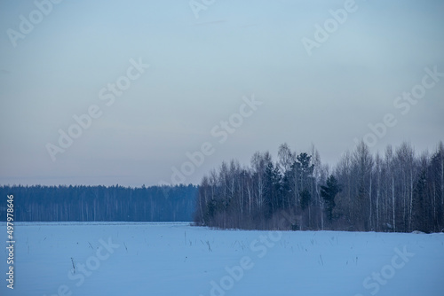 Winter evening landscape, beautiful view of the countryside. Sunset sky over the horizon.