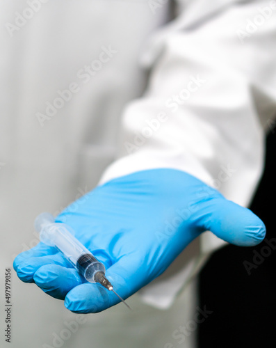 The medical syringe in the doctor's hand is a close-up. A doctor in blue gloves holds a syringe with a coronavirus vaccination. Compulsory vaccination of the population against covid19