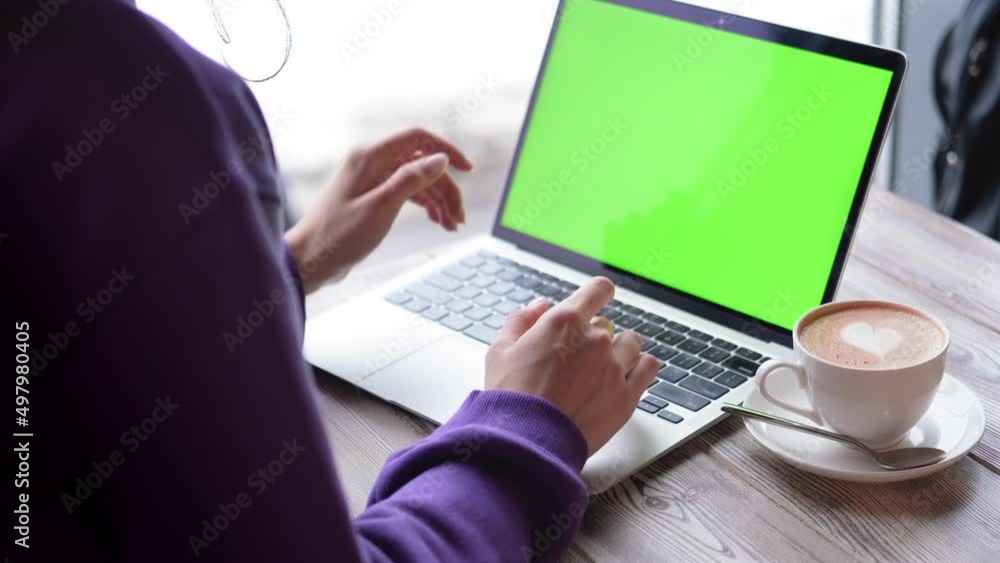 Woman using laptop notebook viewing green screen press browsing chroma key online typing text working remotely on laptop computer close up hands in cafe Woman using laptop notebook viewing green screen press browsing chroma key online typing text working remotely on laptop computer close up hands in cafe