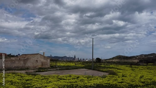Toma aérea de zona rural con el contrate de los enormes rascacielos de Benidorm de fondo, concepto desarrollo urbano