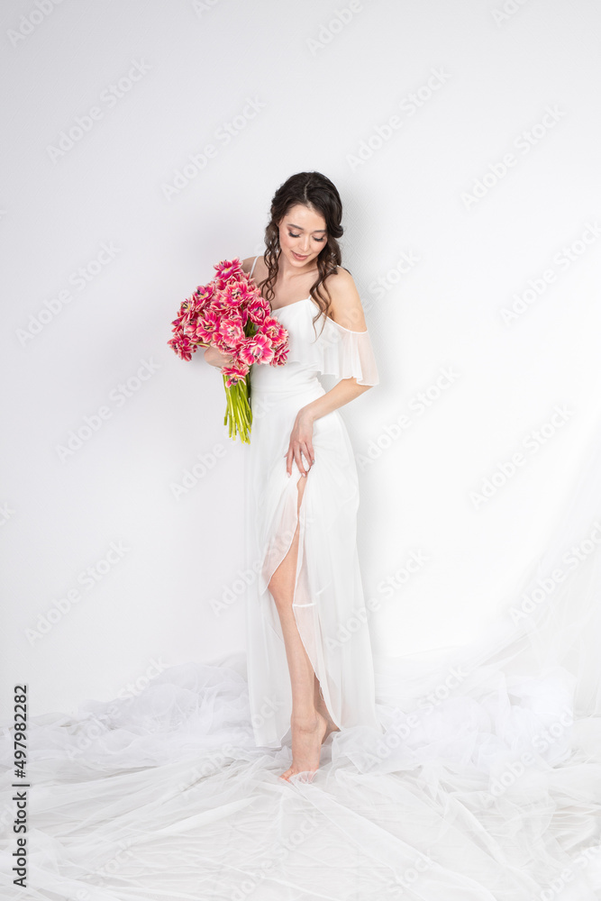 Sexy woman with flowers pink tulips in hands on a light background Sexy woman with flowers pink tulips in hands on a light background