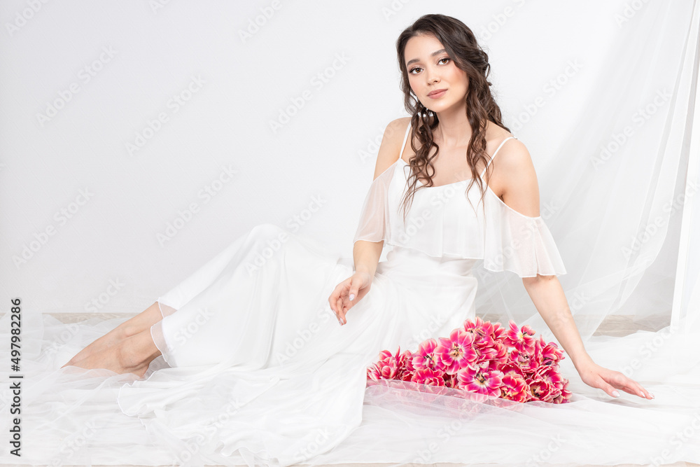Sexy woman with flowers pink tulips in hands on a light background Sexy woman with flowers pink tulips in hands on a light background