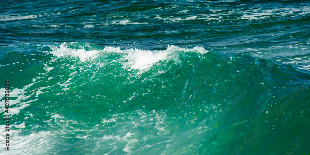 Obraz premium green wave background in natural day light. blurred water and foam texture