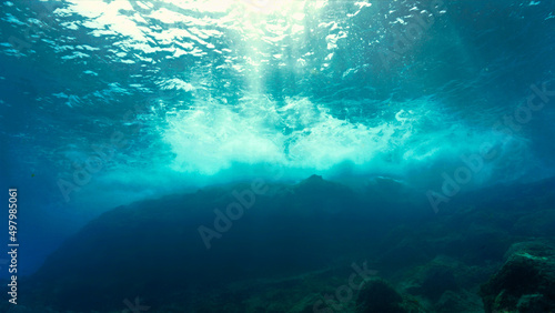 Underwater photo of rays of light at a shallow coral reef.