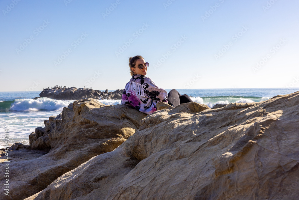 Woman sitting on rocks at the beach
