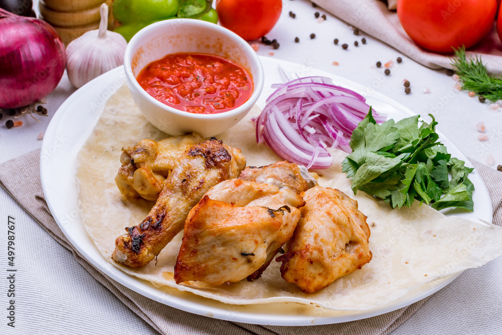 chicken kebab with tomato sauce and red onion on white plate chicken kebab with tomato sauce and red onion on white plate
