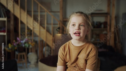  Little girl with a serious look tells something important to the camera