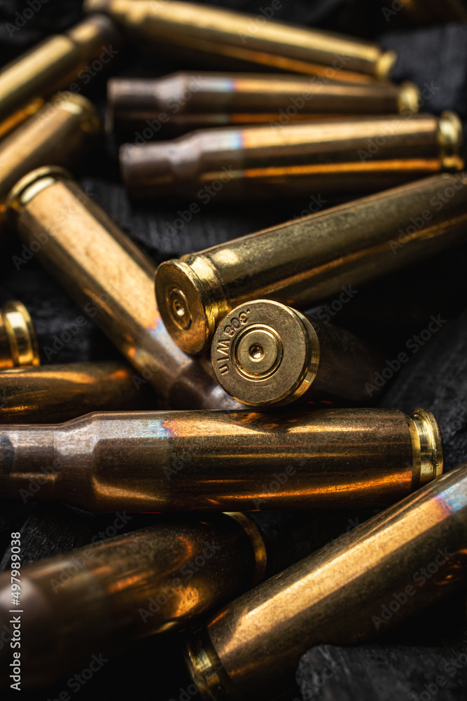 Empty shells from weapons on black smoldering coals. Consequences of the war. Dark back. Empty shells from weapons on black smoldering coals. Consequences of the war. Dark back.