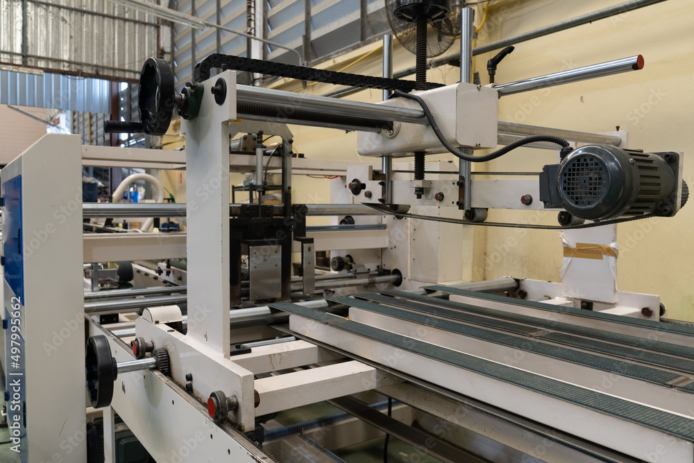 Close up Machine in Paper Box Manufacturer. industrial Concept