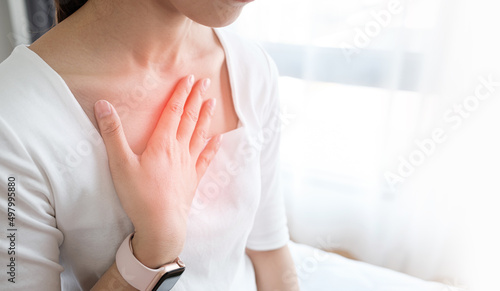 Young woman putting her hand on her chest. Having a pain in chest, Gastroesophageal Reflux Disease have frequent belching. Healthcare medical concept.