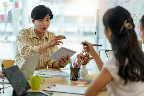 Group of young Asian business people meeting in casual wear working together on new project.