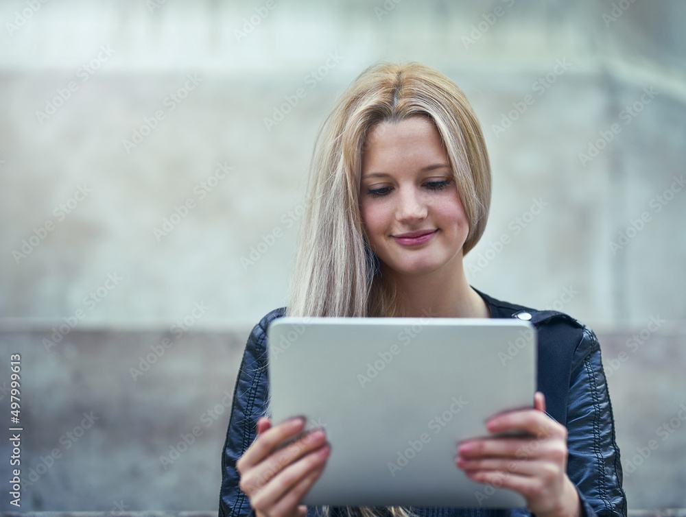 Fototapeta premium If its new, the net will know about it. Shot of an attractive woman using a digital tablet in the city.