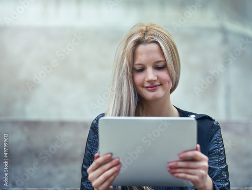 If its new, the net will know about it. Shot of an attractive woman using a digital tablet in the city.