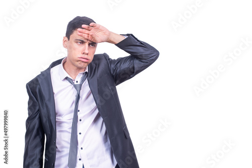 Exhausted businessman touching forehead in light studio photo