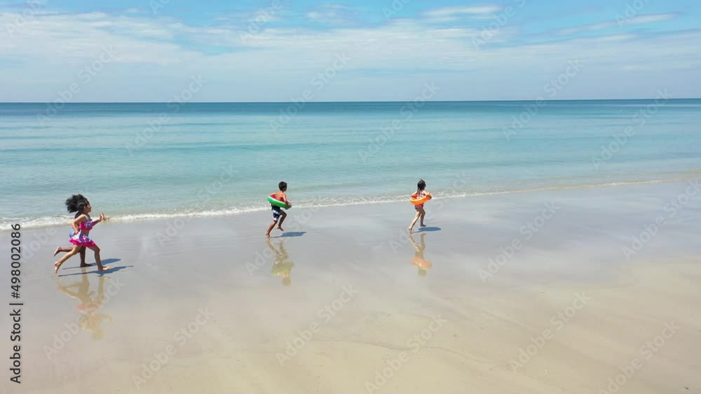 Group of Diversity little child boy and girl friends running and playing in sea water on tropical beach together on summer vacation. Happy children kid enjoy and fun outdoor lifestyle on beach holiday Group of Diversity little child boy and girl friends running and playing in sea water on tropical beach together on summer vacation. Happy children kid enjoy and fun outdoor lifestyle on beach holiday