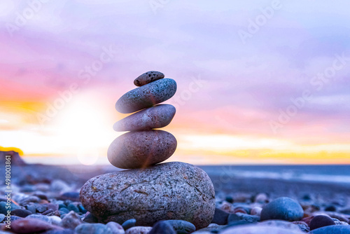 Zen stones stacked on the beach at sunset for balance, harmony, meditation, yoga 