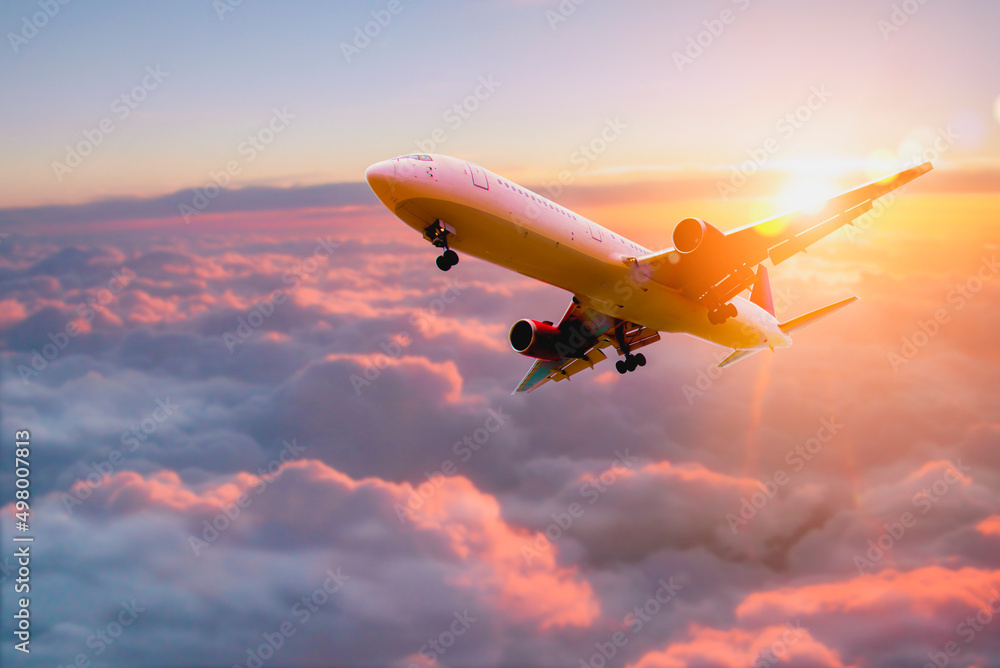 Passenger airplane. Passengers commercial airplane flying above clouds in sunset light. Business trip. Commercial plane. Concept of fast travel, holidays and business. - obrazy, fototapety, plakaty 