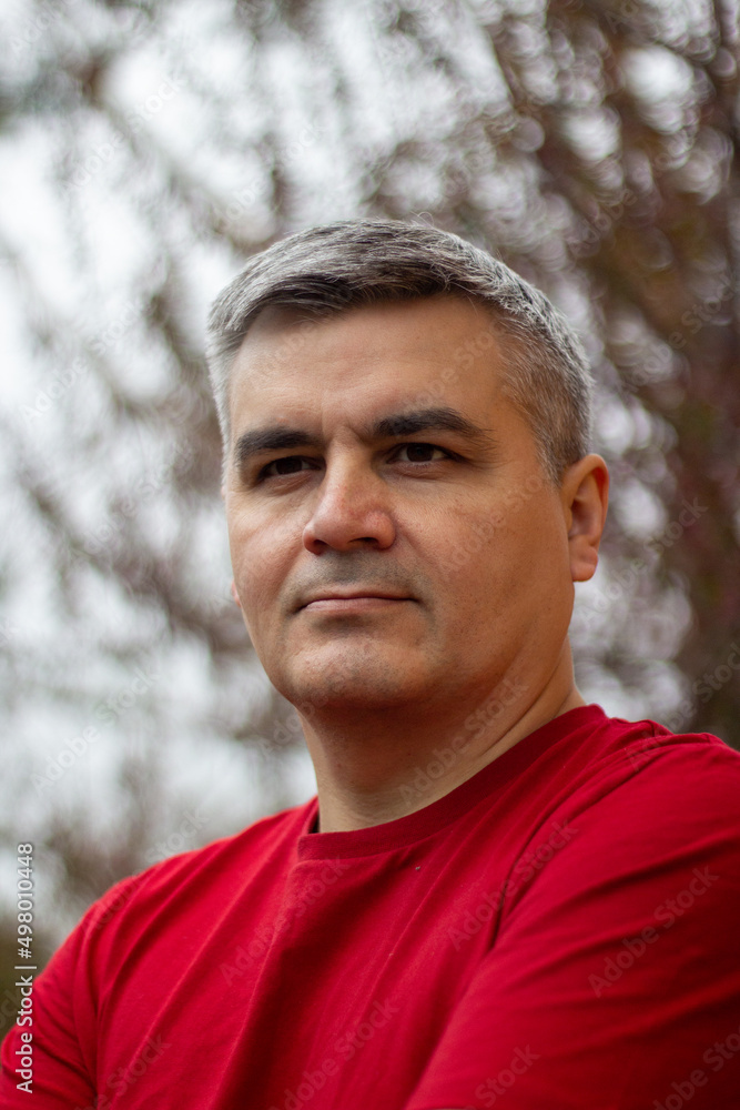 Portrait of a man 40-50 years old, gray-haired, swarthy. Serious look. Big eyebrows. Red jersey. Looking into the distance Portrait of a man 40-50 years old, gray-haired, swarthy. Serious look. Big eyebrows. Red jersey. Looking into the distance