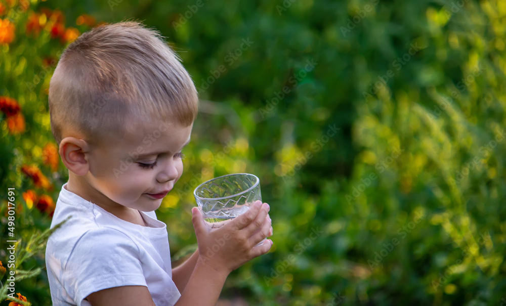 A child drinks water on the background of the field. A child drinks water on the background of the field.