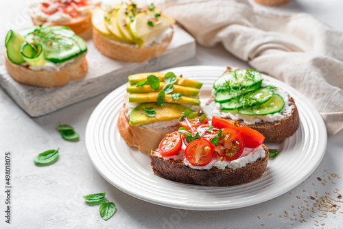 Fresh crostini on rye and wheat bread with vegetables and fruits.