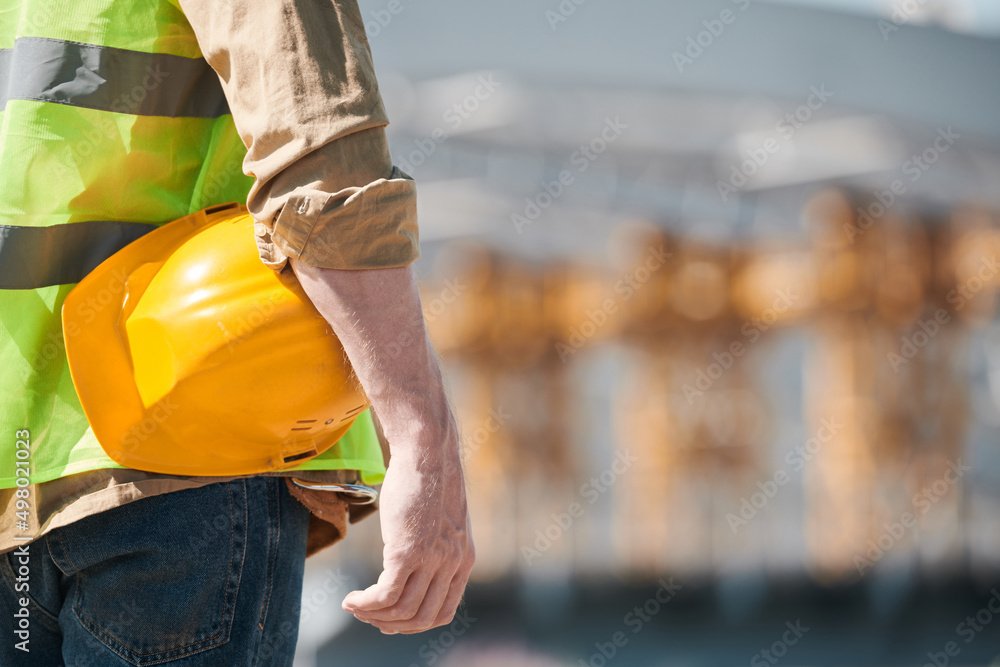 Close up portrait of male construction worker wearing hardhat and looking at camera at construction site, copy space Close up portrait of male construction worker wearing hardhat and looking at camera at construction site, copy space