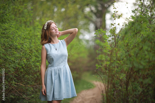 Girl in blue dress in green park