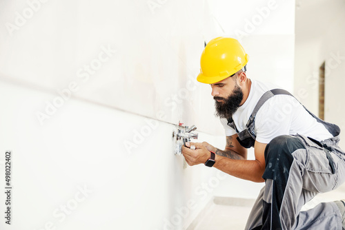A plumber installing pipes in building in construction process.