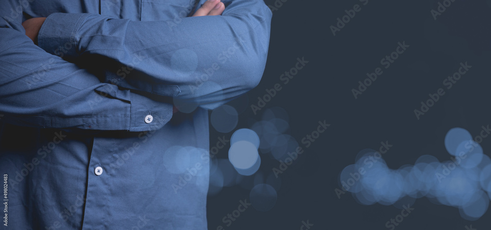 Portrait close up businessman wearing blue shirt standing with his arms crossed on black background with copy space for writing text in studio. Business, financial, and accounting concepts. Portrait close up businessman wearing blue shirt standing with his arms crossed on black background with copy space for writing text in studio. Business, financial, and accounting concepts.