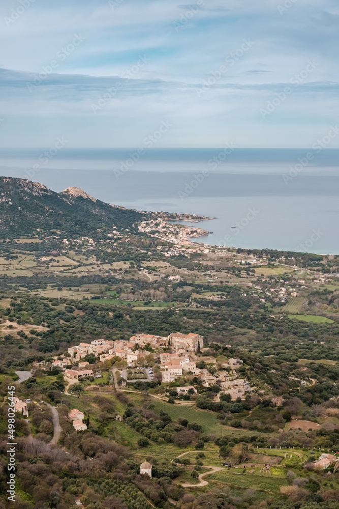 Hilltop village of Pigna in the Balagne region of Corsica with Mediterranean sea in the distance