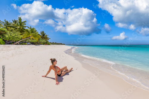 Paradise coast, beautiful island ocean view with sexy woman on sandy beach freedom, relaxing life, enjoying sunny summer weather. Happiness, tourism and leisure tropical beach vacation, travel holiday