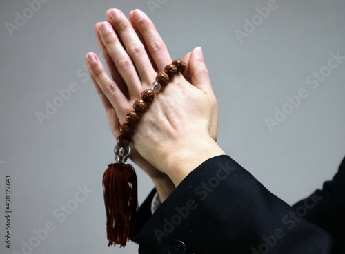 数珠を持ち祈る人物のクローズアップ photo