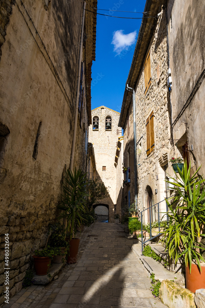 Clocher de l'Eglise Notre-Dame-de-l'Assomption depuis une ruelle du village médiéval des Matelles (Occitanie, France)